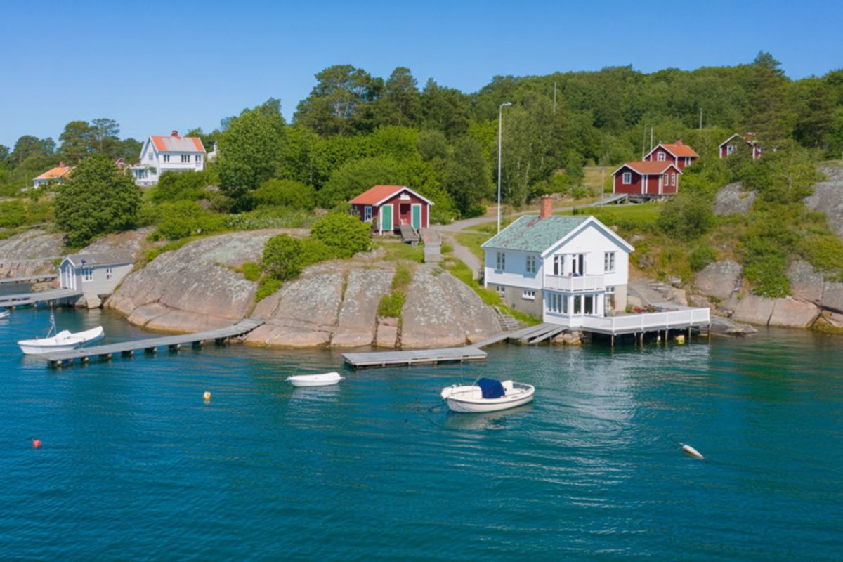 Fina vandringsleder Orust Vildmarknaden.se Röda och vita sommarhus vid klippor och bryggor i ett vackert kustlandskap på Orust.
